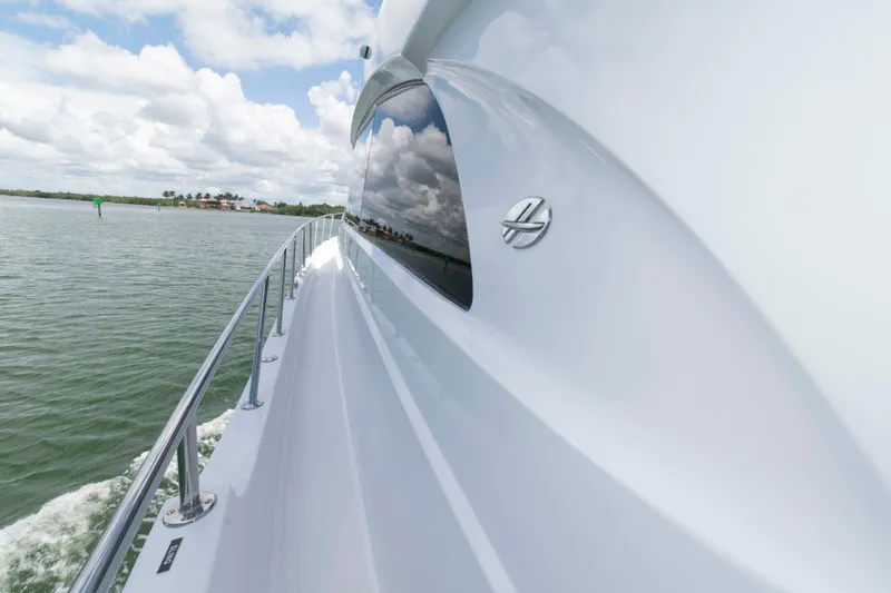 Slide: The Image of 2009 Hatteras 60 Motor Yacht cruising on calm waters under a cloudy sky. - 28