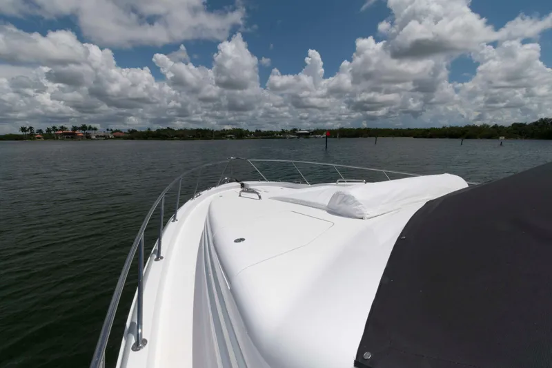 Slide: The Image of 2009 Hatteras 60 Motor Yacht on calm waters under a cloudy sky. - 38