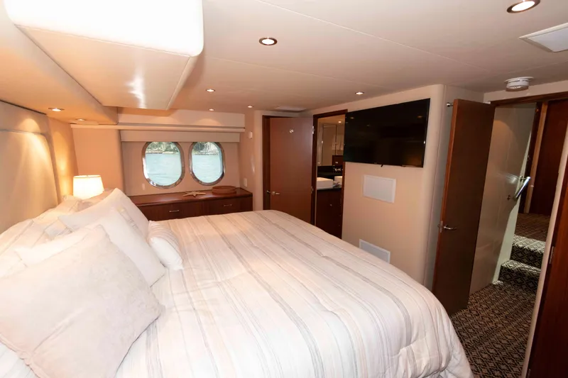 Slide: The Image of Luxurious bedroom interior of 2009 Hatteras 60 Motor Yacht with cozy bed and porthole windows. - 62
