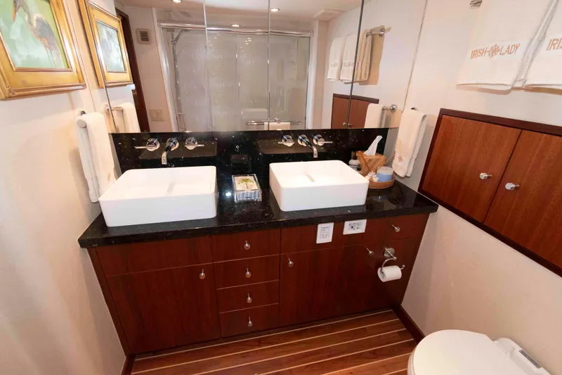 Slide: The Image of Luxurious bathroom in 2009 Hatteras 60 Motor Yacht with dual sinks and elegant wood cabinetry. - 66