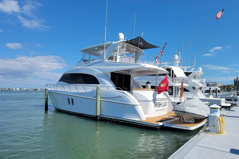Slide: The Image of 2009 Hatteras 60 Motor Yacht docked in sunny marina with flags. - 7