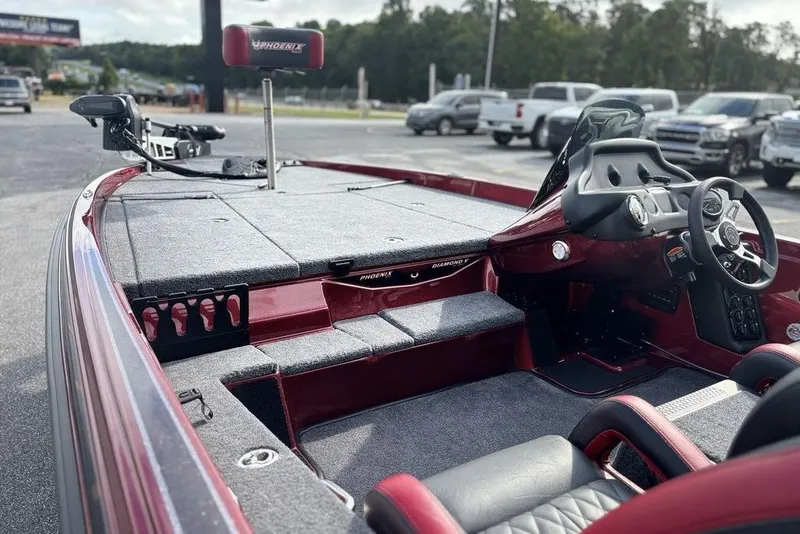 Slide: The Image of 2026 Phoenix 721 ZXL boat interior with steering wheel and seating, parked outdoors. - 15
