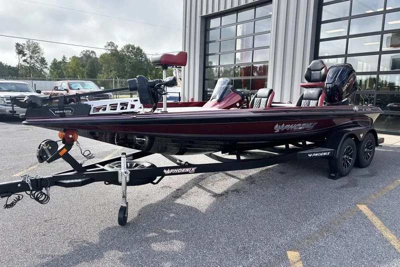 Slide: The Image of 2026 Phoenix 721 ZXL bass boat on trailer, parked outside a building. - 8