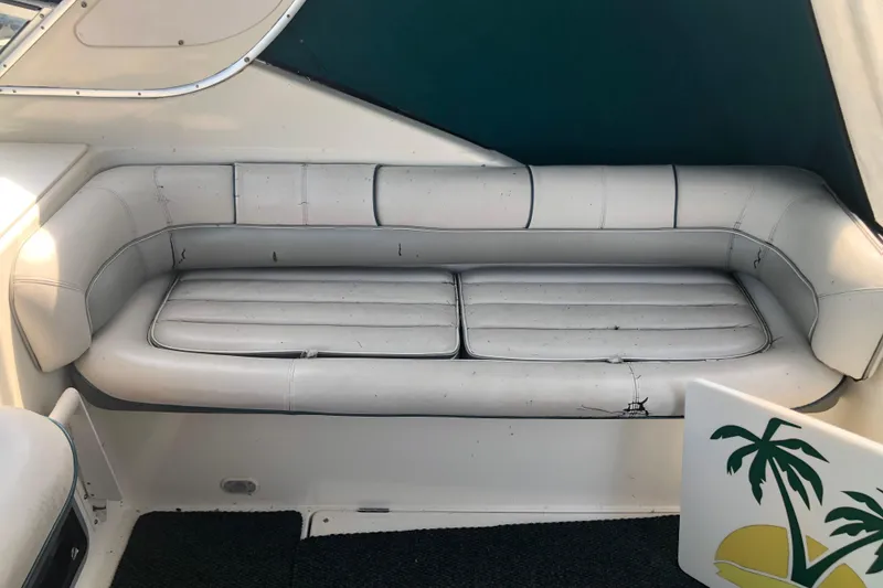 Slide: The Image of White leather seating on a 1995 Maxum 3200 SCR boat, with visible wear and palm tree decor. - 12