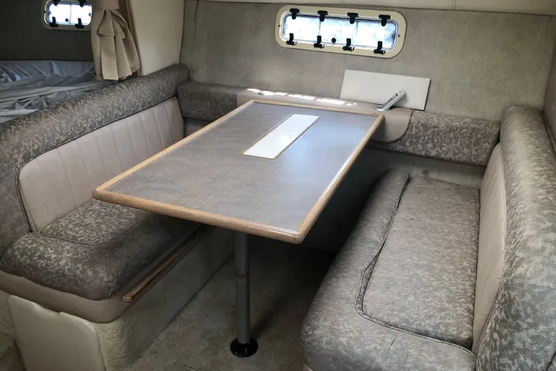 Slide: The Image of 1995 Maxum 3200 SCR cabin interior with dining area and cushioned seating. - 15