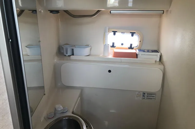Slide: The Image of Compact bathroom in 1995 Maxum 3200 SCR boat, featuring sink and small window. - 19