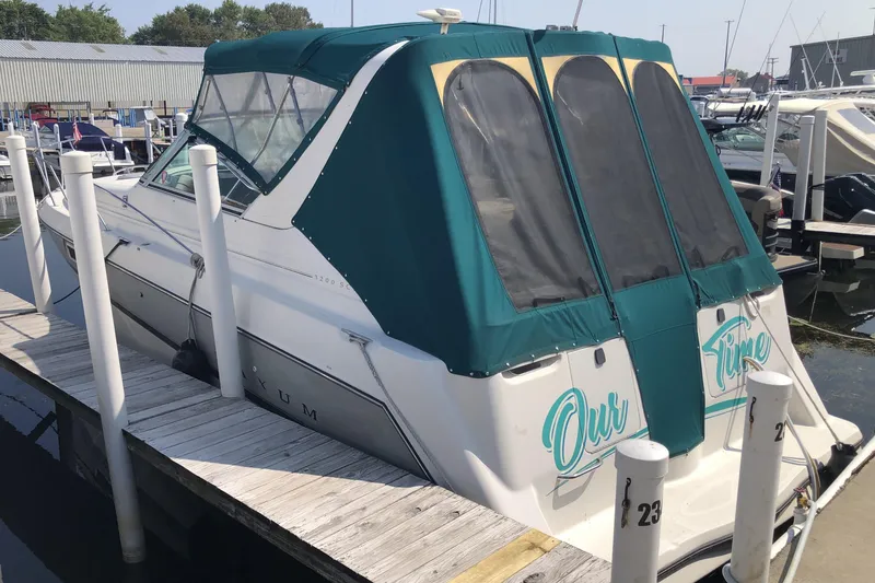 Slide: The Image of 1995 Maxum 3200 SCR boat docked with green canopy and "Our Time" text. - 2