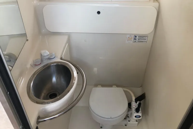 Slide: The Image of 1995 Maxum 3200 SCR boat bathroom with stainless steel sink and compact toilet. - 20