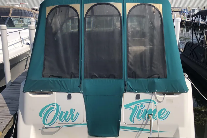 Slide: The Image of 1995 Maxum 3200 SCR boat docked, featuring teal canvas cover and "Our Time" lettering. - 3