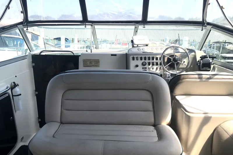Slide: The Image of 1995 Maxum 3200 SCR boat interior with steering wheel and seating area. - 7