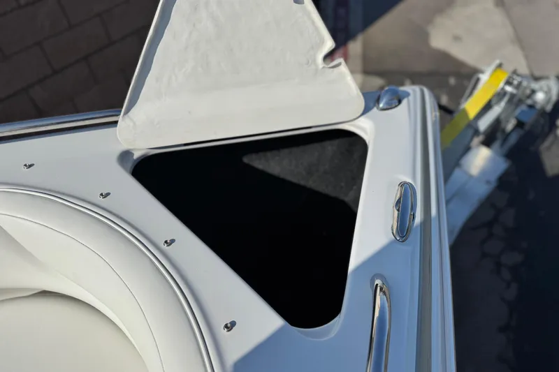 Slide: The Image of 2007 Crownline 270 BR boat with open storage compartment and sleek white design. - 14