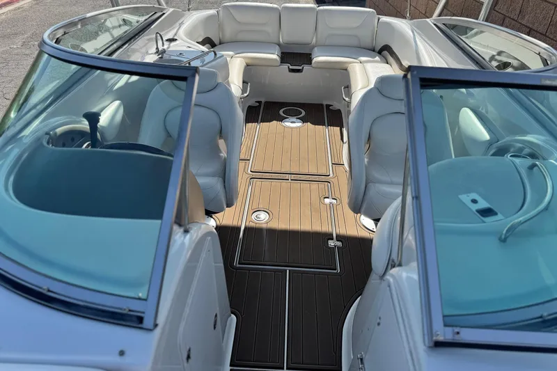 Slide: The Image of 2007 Crownline 270 BR boat interior with white seating and wooden flooring. - 16