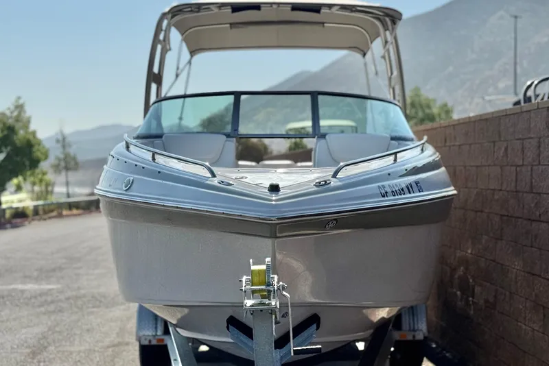 Slide: The Image of 2007 Crownline 270 BR boat on trailer, parked outdoors with mountain backdrop. - 2
