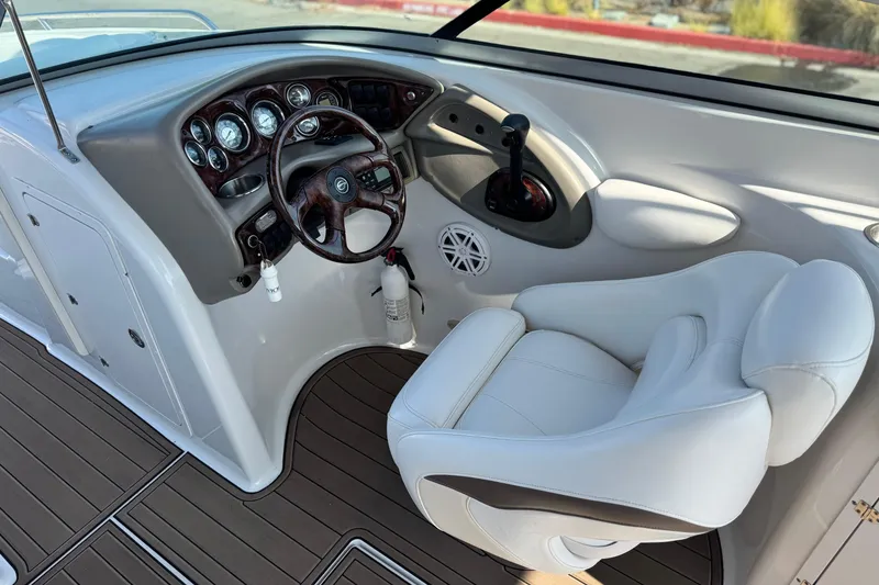 Slide: The Image of 2007 Crownline 270 BR boat cockpit with steering wheel and white captain's chair. - 28