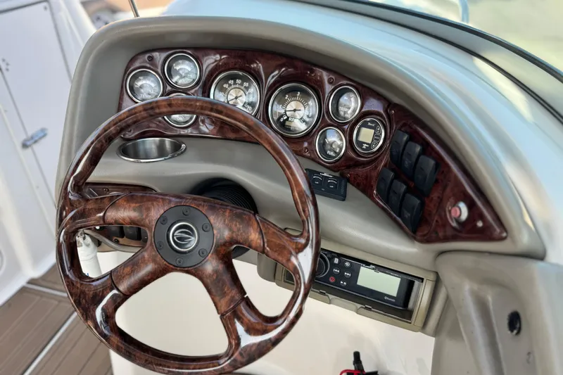 Slide: The Image of Dashboard of a 2007 Crownline 270 BR boat with woodgrain steering wheel and gauges. - 30