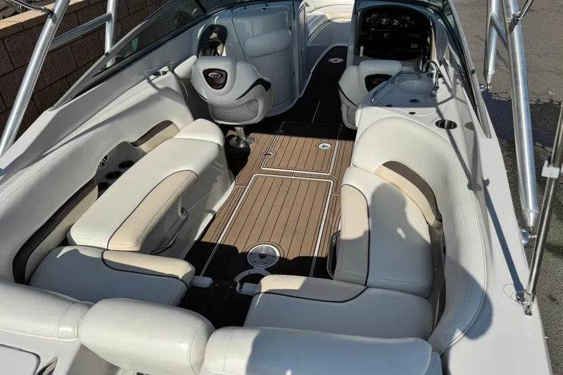 Slide: The Image of 2007 Crownline 270 BR boat interior with white seating and wood flooring. - 9