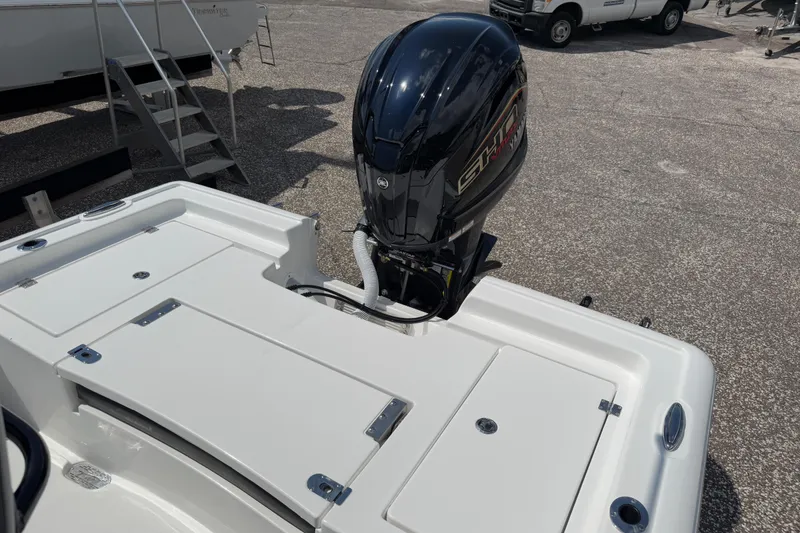 Slide: The Image of 2026 Tidewater 2300 Carolina Bay boat with powerful outboard motor, parked on gravel. - 16