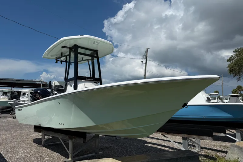 Slide: The Image of 2026 Tidewater 2300 Carolina Bay boat displayed outdoors under cloudy sky. - 2