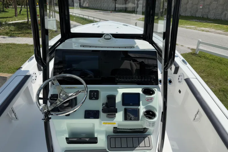 Slide: The Image of 2026 Tidewater 2300 Carolina Bay boat dashboard with steering wheel and electronic controls. - 8