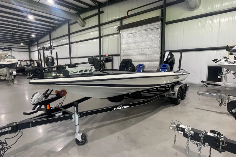 Slide: The Image of 2021 Falcon F21 boat in a warehouse, equipped with Minn Kota trolling motor. - 16