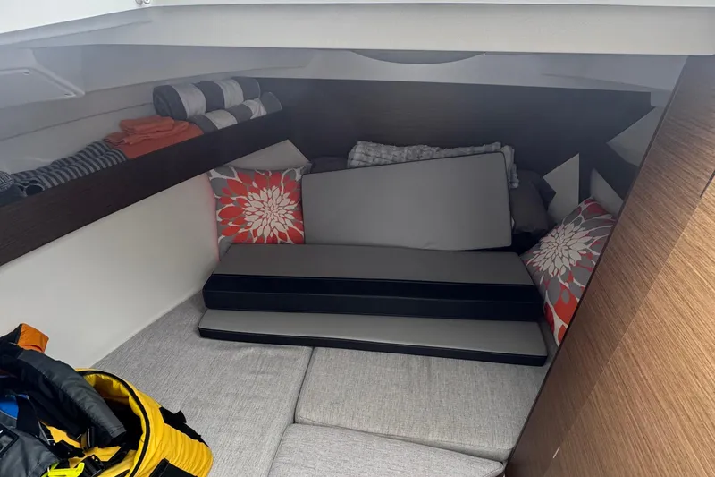 Slide: The Image of 2024 Jeanneau NC 795 cabin interior with cushions and storage shelves. - 2