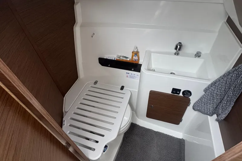 Slide: The Image of 2024 Jeanneau NC 795 bathroom interior with sink, toilet, and wooden accents. - 3