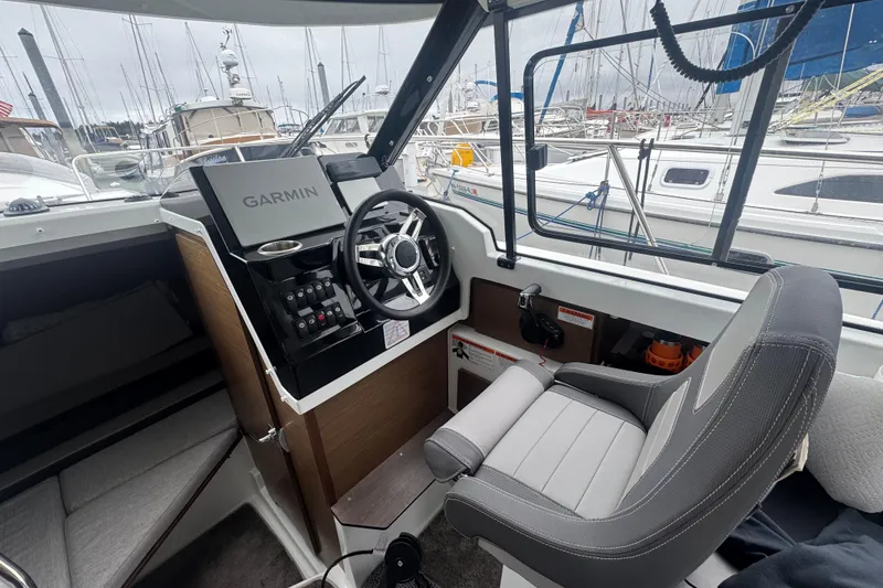 Slide: The Image of 2024 Jeanneau NC 795 cockpit with Garmin navigation, steering wheel, and comfortable seating. - 4