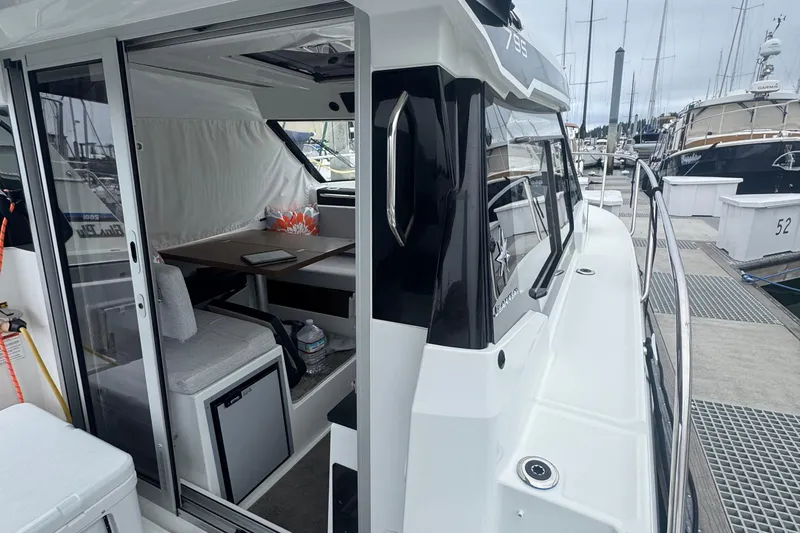 Slide: The Image of 2024 Jeanneau NC 795 boat interior with dining area, docked at marina. - 7