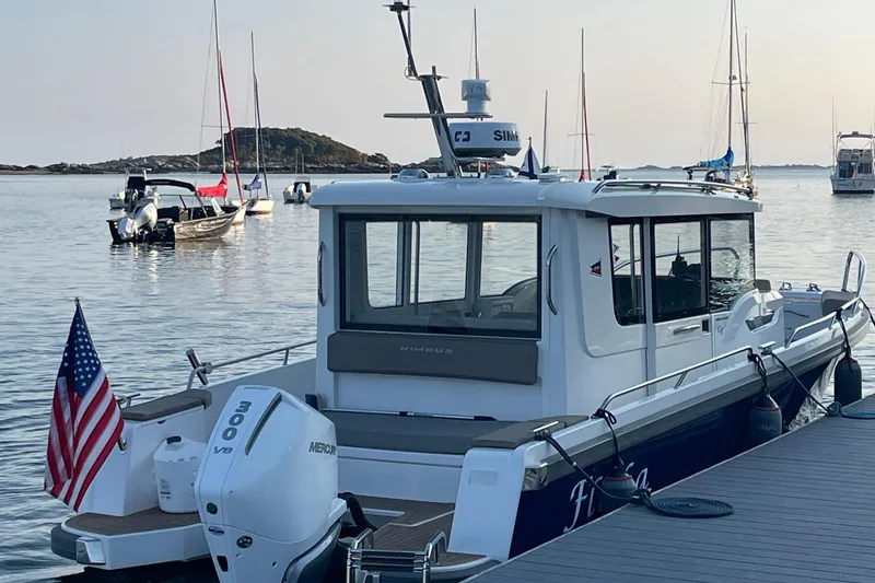 Slide: The Image of Nimbus C9-30 boat docked, 2023 model, with American flag and scenic harbor view. - 11