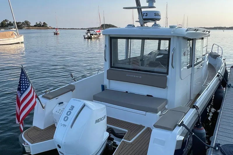 Slide: The Image of 2023 Nimbus c9-30 boat docked, featuring a Mercury 300 V8 engine and American flag. - 12