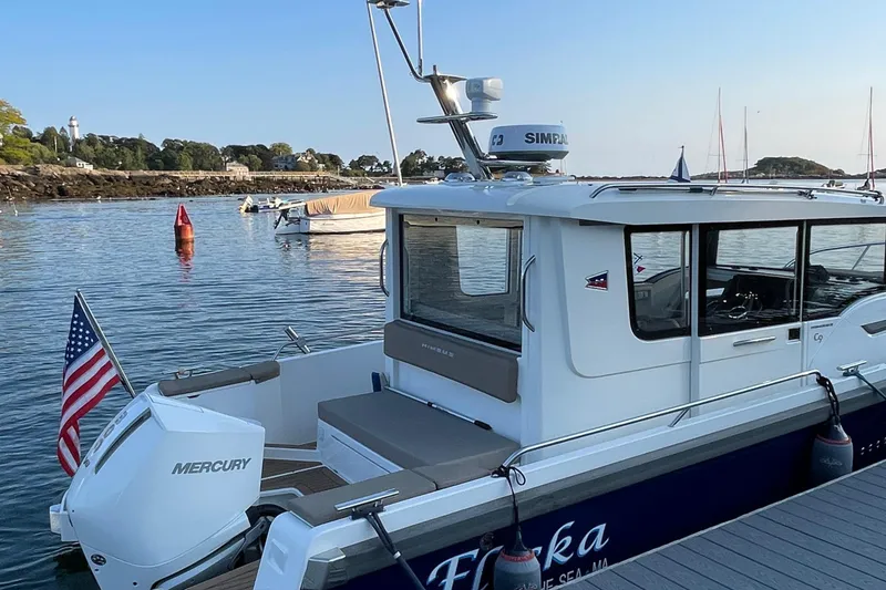Slide: The Image of Nimbus C9-30 boat docked in serene waters, 2023 model, with American flag. - 13