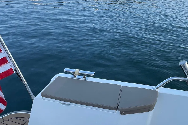 Slide: The Image of 2023 Nimbus c9-30 boat deck with American flag, overlooking calm blue water. - 16