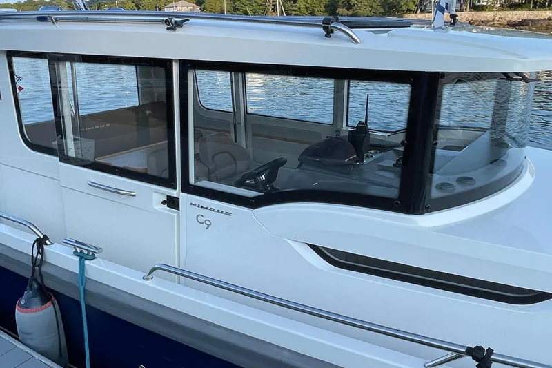 Slide: The Image of 2023 Nimbus C9-30 boat docked by the water, showcasing sleek design and modern features. - 18