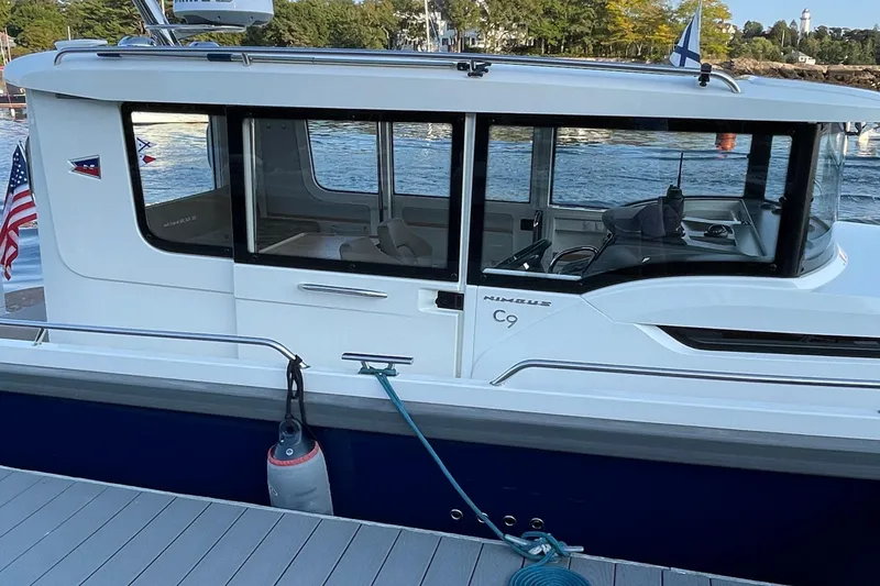Slide: The Image of 2023 Nimbus C9-30 boat docked, featuring sleek design and modern windows. - 22