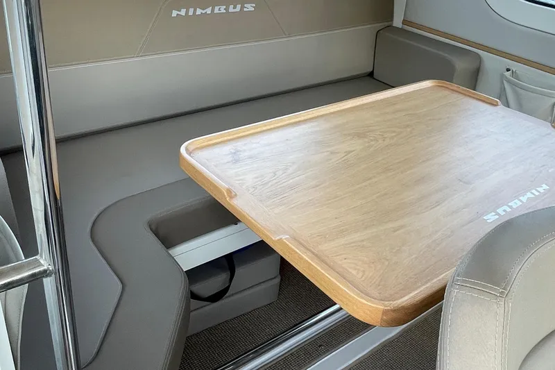Slide: The Image of Interior of 2023 Nimbus C9-30 featuring a wooden table and cushioned seating. - 25
