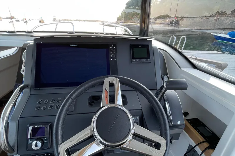 Slide: The Image of Steering console of 2023 Nimbus C9-30 boat with navigation display and controls. - 32
