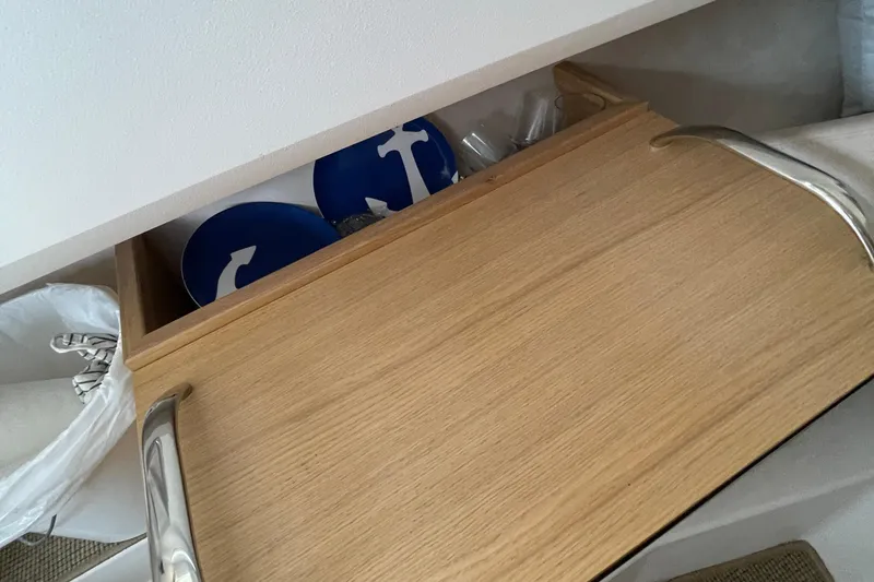 Slide: The Image of Open wooden drawer with blue anchor plates, inside a 2023 Nimbus c9-30 boat. - 33