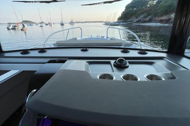 Slide: The Image of Interior view of 2023 Nimbus c9-30 boat cockpit with scenic harbor background. - 37