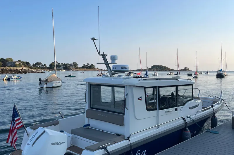 Slide: The Image of Nimbus C9-30 boat docked at marina with sailboats in the background, 2023 model. - 40