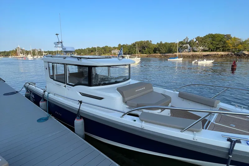 Slide: The Image of 2023 Nimbus C9-30 boat docked by a scenic waterfront with trees and sailboats. - 41