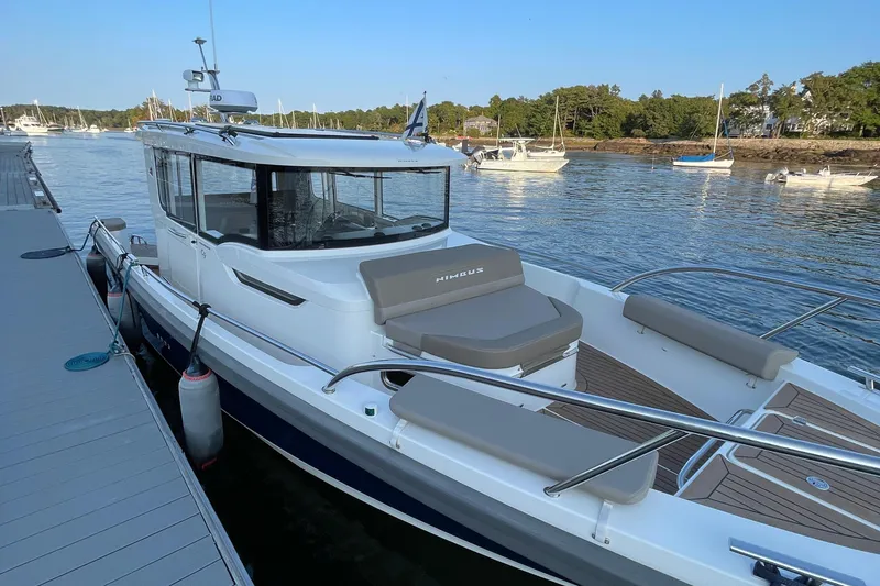 Slide: The Image of 2023 Nimbus c9-30 boat docked at marina, surrounded by calm water and other boats. - 43