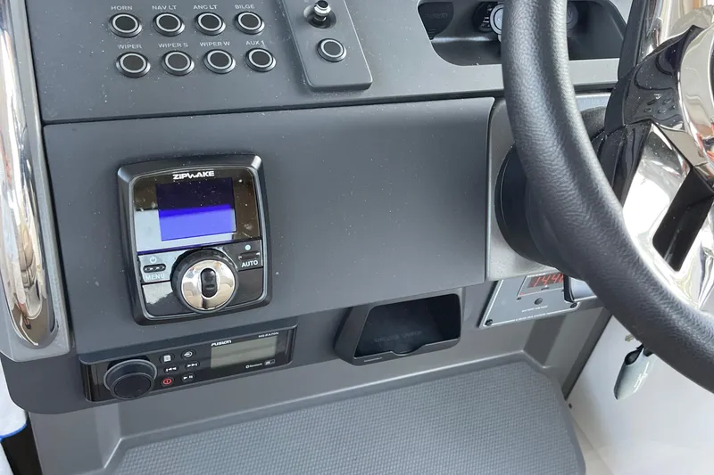 Slide: The Image of Control panel of 2023 Nimbus c9-30 boat with steering wheel and electronic displays. - 46