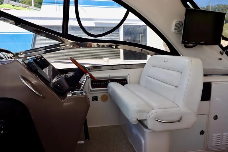 Slide: The Image of Interior of 2006 Regal Commodore 4460 yacht with white seating and control panel. - 11