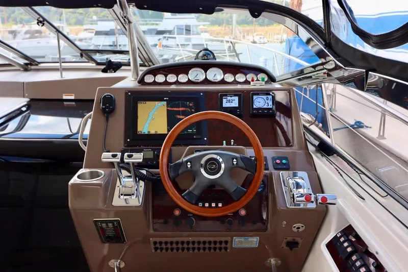 Slide: The Image of 2006 Regal Commodore 4460 yacht helm with navigation system and wooden steering wheel. - 14
