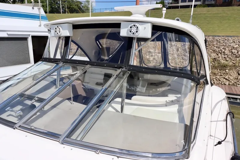 Slide: The Image of 2006 Regal Commodore 4460 boat with glass windshield and speakers, docked near grassy area. - 18