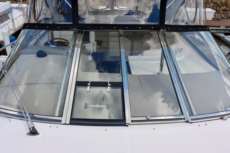 Slide: The Image of 2006 Regal Commodore 4460 yacht with sleek glass cockpit and reflective windows. - 23