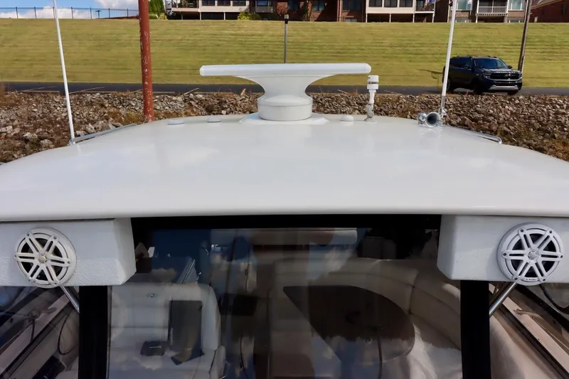 Slide: The Image of 2006 Regal Commodore 4460 yacht roof with speakers and radar, docked near grassy area. - 24