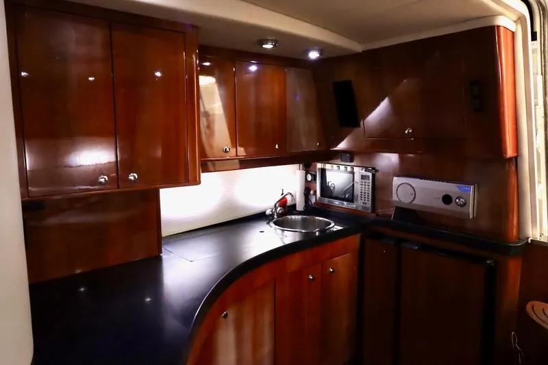 Slide: The Image of Luxurious 2006 Regal Commodore 4460 yacht kitchen with wood cabinets and modern appliances. - 25