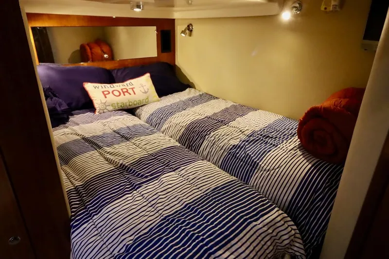 Slide: The Image of Cozy cabin bedroom in 2006 Regal Commodore 4460 yacht with striped bedding. - 30