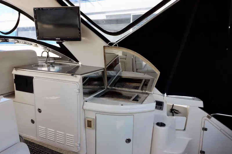 Slide: The Image of 2006 Regal Commodore 4460 yacht interior with kitchenette and TV setup. - 8